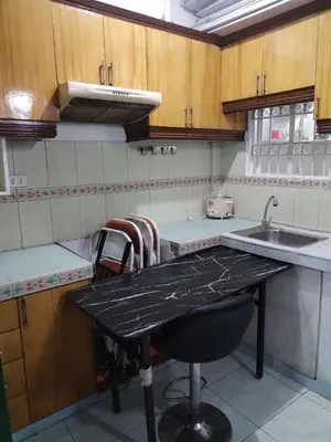 a kitchen with a black counter top and a sink at male bedspace in Manila