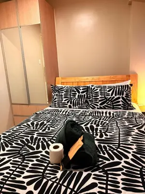 a black and white bed with a roll of toilet paper on it at BayHaus MNL - Pet-friendly Condo Near MOA in Manila