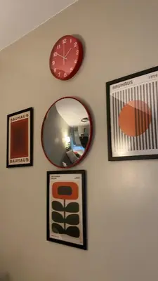 a wall with pictures and a clock and a mirror at BayHaus MNL - Pet-friendly Condo Near MOA in Manila