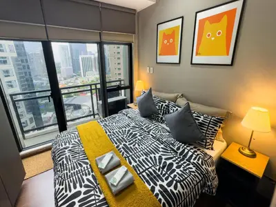 a bedroom with a bed with a view of a city at Place in Century Poblacion in Manila