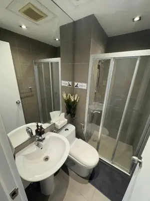 a bathroom with a toilet and a sink and a shower at Place in Century Poblacion in Manila