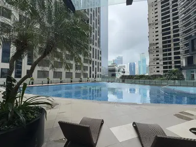 a large swimming pool in a city with buildings at Place in Century Poblacion in Manila