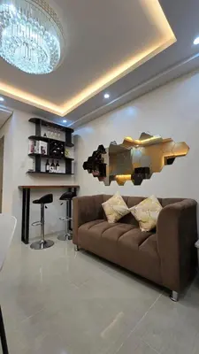 a living room with a brown couch and a bar at Sevillano's City Escape at Shore 1 Near MOA in Manila