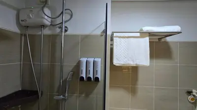 a bathroom with a shower with a glass door at Sevillano's City Escape at Shore 1 Near MOA in Manila