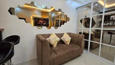 a living room with a couch and a mirror at Sevillano's City Escape at Shore 1 Near MOA in Manila