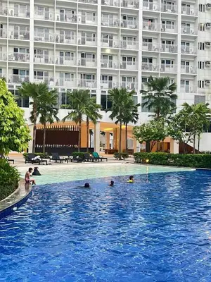 a swimming pool in front of a large building at Sevillano's City Escape at Shore 1 Near MOA in Manila