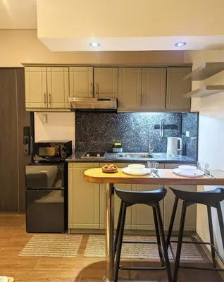 a kitchen with a wooden table with two stools at BBricks Alabang Beside Festival Mall in Manila