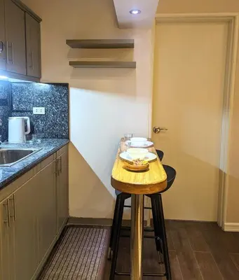 a small kitchen with a small wooden table in it at BBricks Alabang Beside Festival Mall in Manila