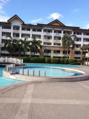 a swimming pool in front of a large building at One Oasis Ortigas H212 in Manila