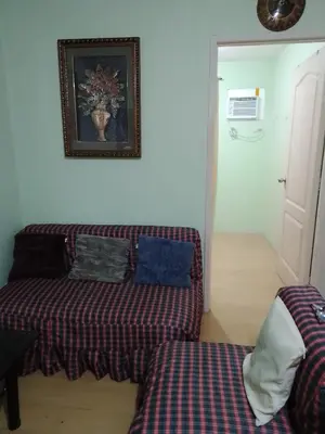 a couch and a bed in a room at One Oasis Ortigas H212 in Manila