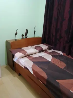 a bed with a comforter and pillows on it at One Oasis Ortigas H212 in Manila
