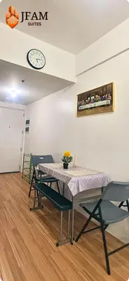 a table and chairs in a room with a clock on the wall at JFam Suites, C4-10U Studio, Up To 4 Pax in Biñan