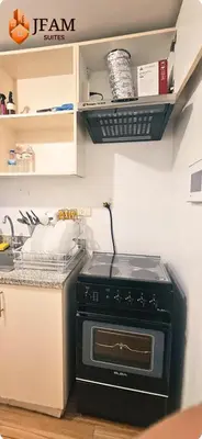 a kitchen with a black stove in a kitchen at JFam Suites, C4-10U Studio, Up To 4 Pax in Biñan