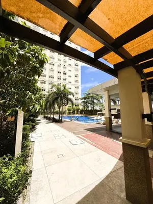 a view of a swimming pool and a building at JFam Suites, C4-10U Studio, Up To 4 Pax in Biñan