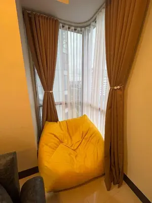 a yellow bean bag chair in front of a window at Modern Spacious 2BR 68 sqm Condo in Manhattan Heights Pool View in Manila