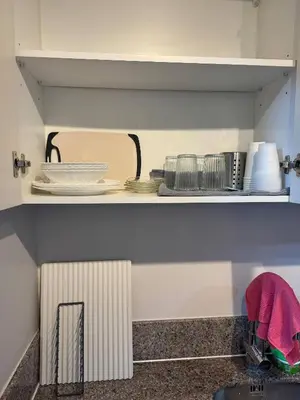 a kitchen counter with plates and dishes on a shelf at Modern Spacious 2BR 68 sqm Condo in Manhattan Heights Pool View in Manila