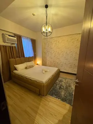 a bedroom with a bed and a chandelier at Modern Spacious 2BR 68 sqm Condo in Manhattan Heights Pool View in Manila