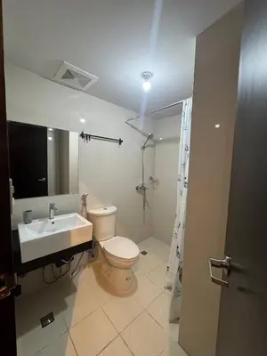 a bathroom with a toilet and a sink and a shower at Modern Spacious 2BR 68 sqm Condo in Manhattan Heights Pool View in Manila