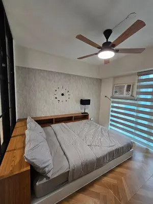 a bedroom with a bed and a ceiling fan at Affordable Condo Suite with WIFI in McKinley BGC in Manila