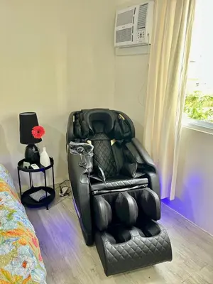 a black leather reclining chair in a bedroom at Nuvali - Free use of Massage Chair-Pool Access-Hot Shower in Calamba