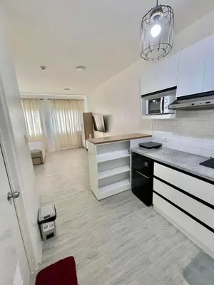 a kitchen with white cabinets and a counter top at Nuvali - Free use of Massage Chair-Pool Access-Hot Shower in Calamba