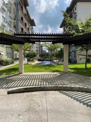 a bench in a park in front of a building at Nuvali - Free use of Massage Chair-Pool Access-Hot Shower in Calamba