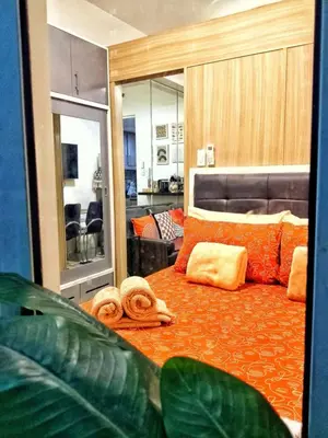 a bedroom with an orange bed with towels on it at DS Staycation in Manila