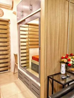 a walk in closet with a mirror and a table at DS Staycation in Manila