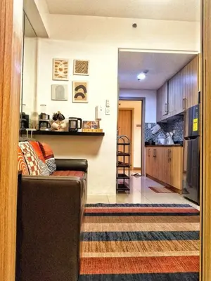 a living room with a couch and a kitchen at DS Staycation in Manila