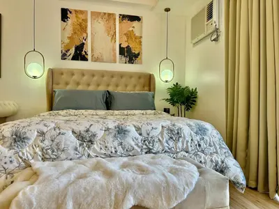 a bedroom with a large bed in a room at Modern Condo at The Venice Luxury Mckinley Hill in Manila