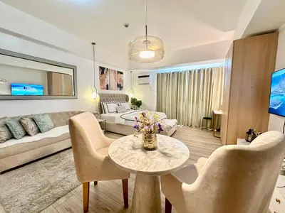 a living room with a couch and a table at Modern Condo at The Venice Luxury Mckinley Hill in Manila