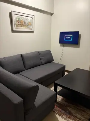 a living room with a couch and a tv at Modern 2BR Condo with Balcony in Central Manila in Manila