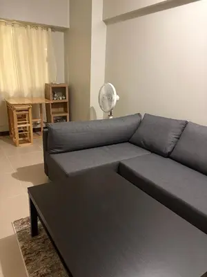 a living room with a blue couch and a table at Modern 2BR Condo with Balcony in Central Manila in Manila