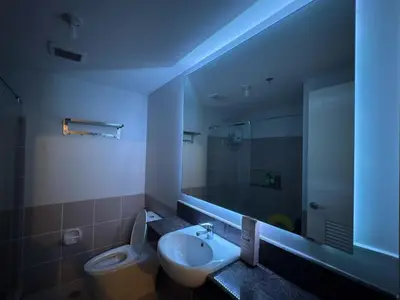 a bathroom with a sink and a toilet and a mirror at Modern 2BR Condo with Balcony in Central Manila in Manila