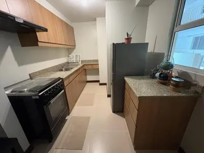 a small kitchen with a refrigerator and a sink at Modern 2BR Condo with Balcony in Central Manila in Manila