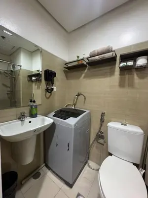 a bathroom with a toilet and a sink at Balay Maria at Shore in Manila