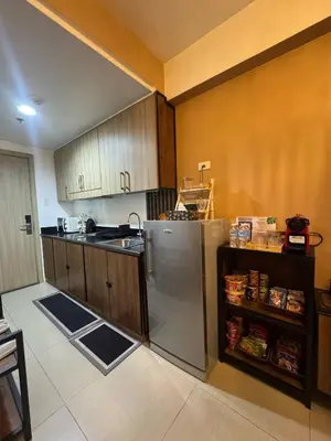 a kitchen with a stainless steel refrigerator and wooden cabinets at Balay Maria at Shore in Manila
