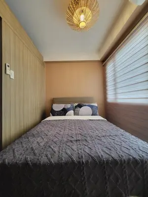a bedroom with a large bed with a chandelier at Balay Maria at Shore in Manila