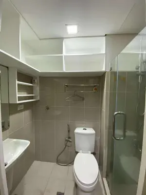 a bathroom with a toilet and a shower and a sink at Shore Staycation in Manila