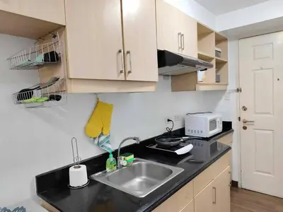 a kitchen with a sink and a microwave at Windsong Suite Unli Netflix Disney Roofdeck View in Manila