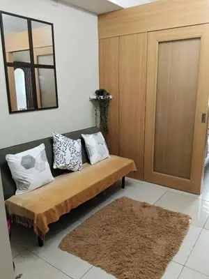 a room with a couch with pillows and a mirror at Serene Pasay Getaway - Entire Apartment for Rent in Manila