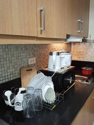 a kitchen counter with dishes on a drying rack at Serene Pasay Getaway - Entire Apartment for Rent in Manila