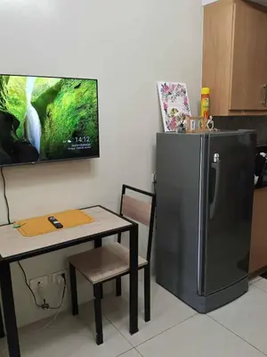 a kitchen with a table and a refrigerator at Serene Pasay Getaway - Entire Apartment for Rent in Manila