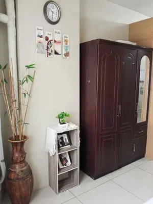 a room with a cabinet and a clock on the wall at Serene Pasay Getaway - Entire Apartment for Rent in Manila