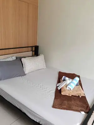a bed with a tray with two towels on it at Serene Pasay Getaway - Entire Apartment for Rent in Manila