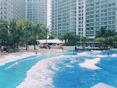 a swimming pool with blue water and tall buildings at 1BR Unit Azure Urban Resort Residences in Manila