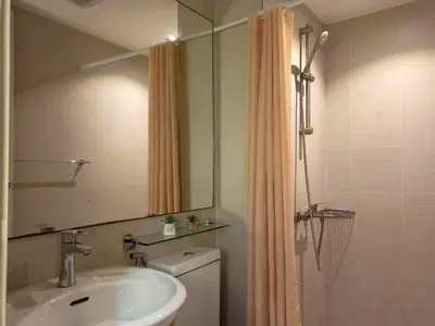 a bathroom with a sink and a toilet and a mirror at 1BR Unit Azure Urban Resort Residences in Manila