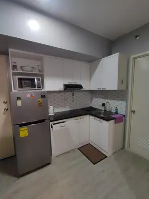 a kitchen with white cabinets and a stainless steel refrigerator at 1Bedroom for rent Amaia Skies Shaw in Manila