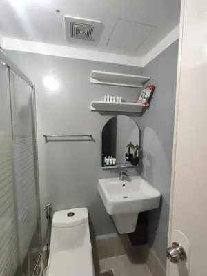a white bathroom with a toilet and a sink at 1Bedroom for rent Amaia Skies Shaw in Manila