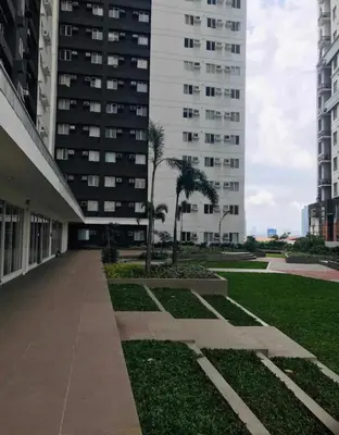 a large white building with palm trees and a park at 1Bedroom for rent Amaia Skies Shaw in Manila
